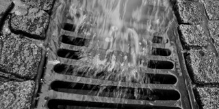 Water running into a storm drain grate.